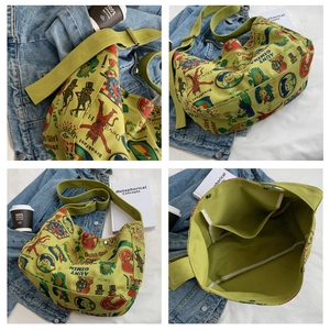 Detail view of green canvas tote bag with retro cartoon print and spacious interior compartments