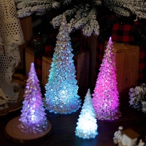 Colorful LED acrylic crystal mini Christmas tree lights on cozy festive tabletop