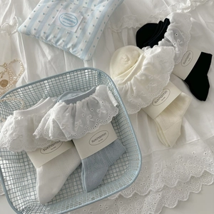 Chaussettes en coton avec dentelle blanche et bleue présentées dans un panier déco