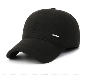 Detail of black knitted baseball cap showing fine wool texture and silver metal fashion label