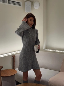 Close-up of a grey chunky knit dress with vertical ribbing and button-up high collar detail