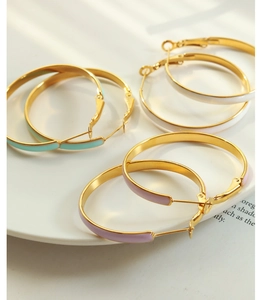 Detail of three-color enamel hoop earrings in gold finish with latch-back closure