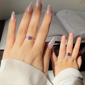 Detailed view of parent-child silver ring set with oval blue gemstones on a hand