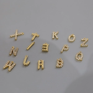 Macro shot of 18k gold plated letter pendants with cubic zirconia for DIY jewelry
