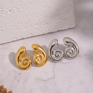 Polished spiral vortex conch earrings in gold and silver finish on stone background