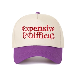 Close-up of red 'Expensive & Difficult' embroidery on a two-tone baseball cap