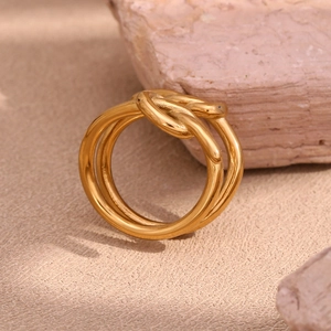 Détail d'une bague en acier inoxydable plaqué or 18K avec un design à triple nœud