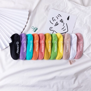Flat lay of 11 colorful low cut socks with Happy text and smiley face patterns