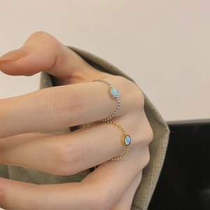 Macro shot of artificial opal bead ring with gold and silver elastic chain bands