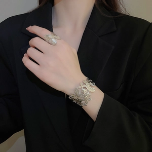 Vista dettagliata della trama a petalo argentato sul bracciale a fascia e anello coordinato