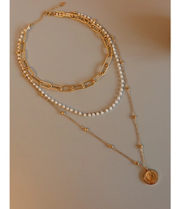 Detailed view of triple-layered titanium steel necklace with gold coin pendant and pearls