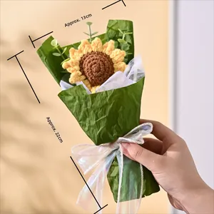 Detailed view of handmade knitted sunflower bouquet with green paper and ribbon