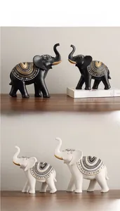 Detail view of resin elephant statues in black and white with gold tusks and boho patterns