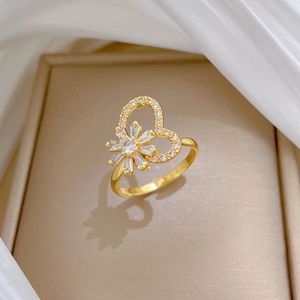 Macro detail of gold flower and heart ring with white zircons on a jewelry box