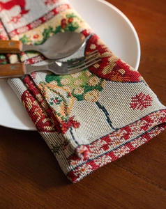 Close-up of Christmas table runner fabric showing reindeer and snowflake jacquard texture
