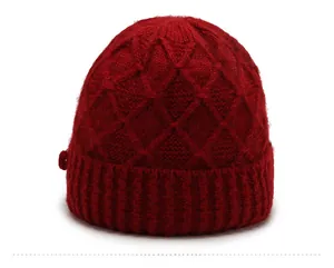 Detail of dark red knit winter hat with thick diamond weave and ribbed brim for women