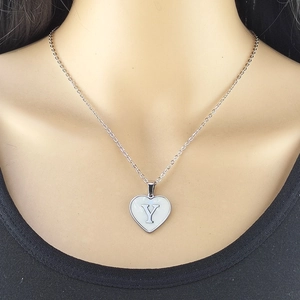 Silver heart necklace with white shell inlay and letter Y pendant on neck