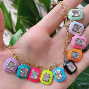 Octagon colorful enamel charms bracelet with rectangular crystals held by a hand