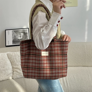Macro shot of retro plaid wool fabric and minimalist white label on a large tote bag