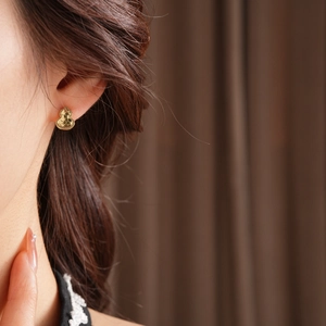 Close-up of 18k gold plated gourd earrings on model for a vintage minimalist look