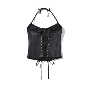 Dettaglio del corsetto in raso nero con occhielli stringati e consistenza setosa