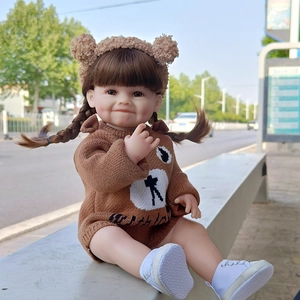 Detailed realistic baby doll wearing brown teddy bear ear headband and knit sweater