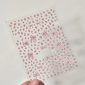 Detail von dünnen Nagelaufklebern mit rosa Leopardenmuster und Schleifendesigns