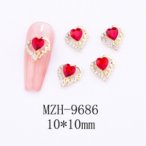 Macro view of 10mm red heart gem nail charms with gold Love engraving and white rhinestones