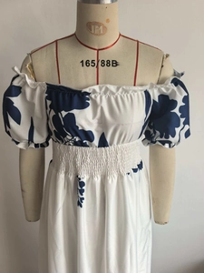 Détail d'une robe fleurie bleue avec manches bouffantes et taille haute élastique froncée