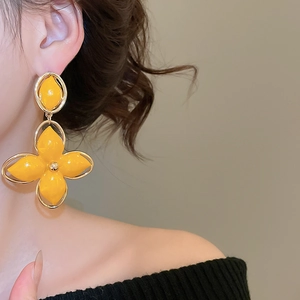 Détail des boucles d'oreilles fleurs jaunes sur modèle pour un style de mode vintage