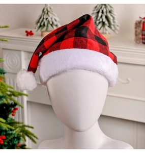 Close-up of red and black plaid Christmas hat with plush trim in festive home setting