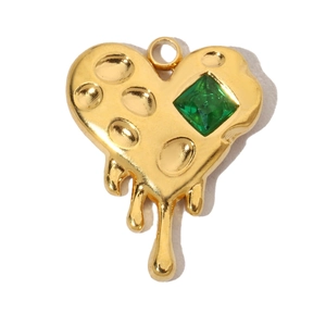 Detailed shot of a gold heart pendant featuring a green gemstone and molten fluid texture