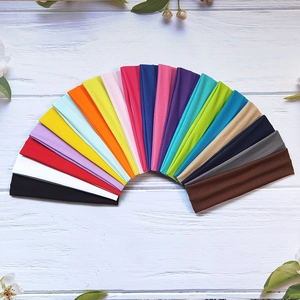 Detailed top view of multi-colored high elasticity yoga headbands on a rustic wood background