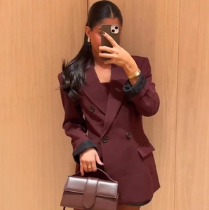 Blazer doppiopetto bordeaux da donna abbinato a borsa a mano e accessori coordinati