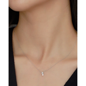 Close-up of minimalist S925 silver necklace with pearl and sparkling zircon pendant