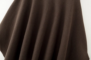 Detailansicht aus dunklem braunem Strickstoff mit weicher Textur und feinem Fall