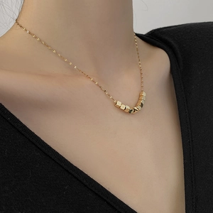 Close-up of a gold square bead necklace displayed on a model's neck for styling