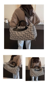 Dettagli della borsa da viaggio con motivo geometrico bianco e nero e manici in pelle