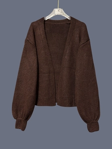 Detail view of the deep brown knit cardigan with thick woolen texture and V-neckline
