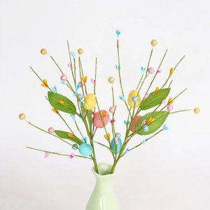 Easter decorative branch with colorful speckled eggs and faux berries in a green vase