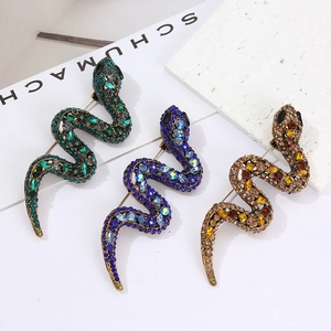 Vintage crystal encrusted snake brooches in green, blue, and brown gold finishes