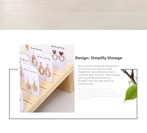 Macro detail of tiered wooden earring display stand for jewelry retail organization
