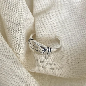 Macro shot of 925 silver ring featuring Love you to the moon and back engraving