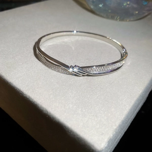 Détail macro du bracelet à boucle ondulée plaqué or 18K avec zircons scintillants