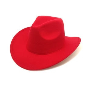 Close-up of vibrant red felt western cowboy hat with wide brim on white background