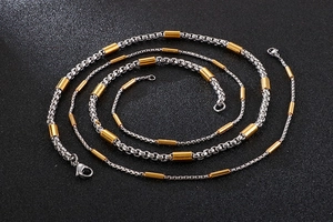 Detail of square box chain necklace with gold cylinder beads and lobster clasp closure
