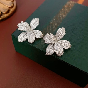 Makroaufnahme der Blumen-Ohrringe mit Zirkonia auf einer grünen Schmuckschatulle