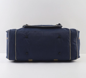 Detail view of the deep blue travel bag bottom with four protective black feet and beige piping