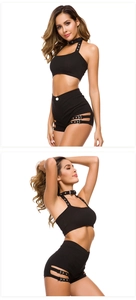 Dettaglio dei mini shorts neri a vita alta con ritaglio laterale e fibbia in argento