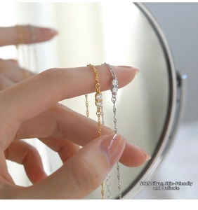 Macro shot of S925 sterling silver water wave chain with sparkling zircon detail
